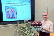 Frau hält Tablett mit Cocktailgläsern, dahinter Bildschirm