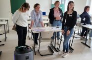 5 Frauen prüfen die Fähigkeiten eines modernen Reinigungsroboters