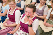 Sitzende Frau beißt in Medaille